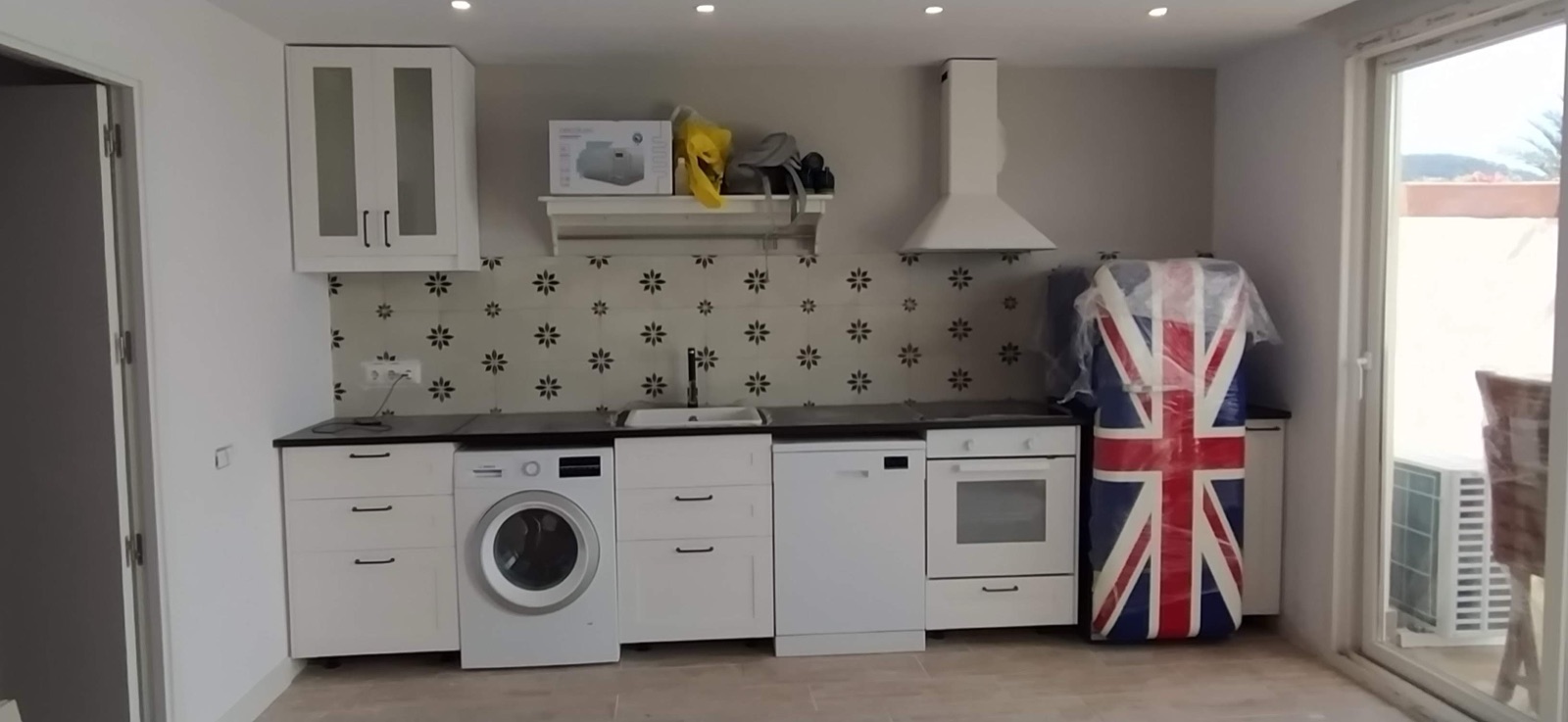 Cocina completa montada con muebles, encimera y electrodomésticos